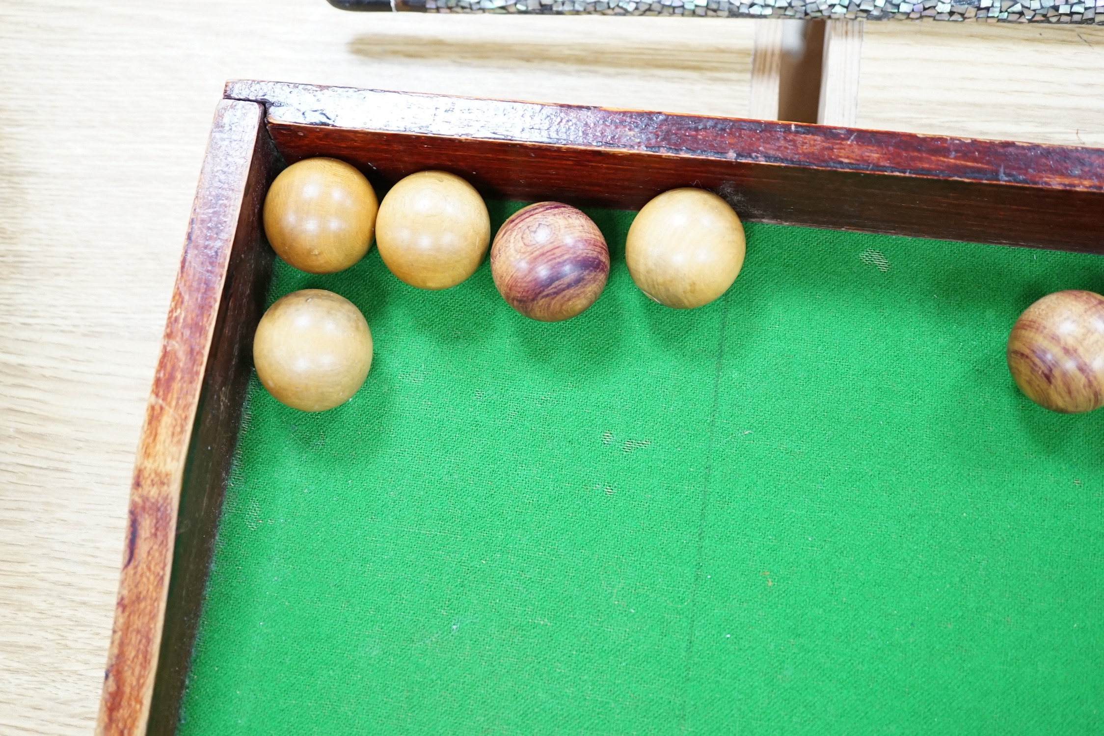 A bagatelle board, balls and cues, 108cm in length